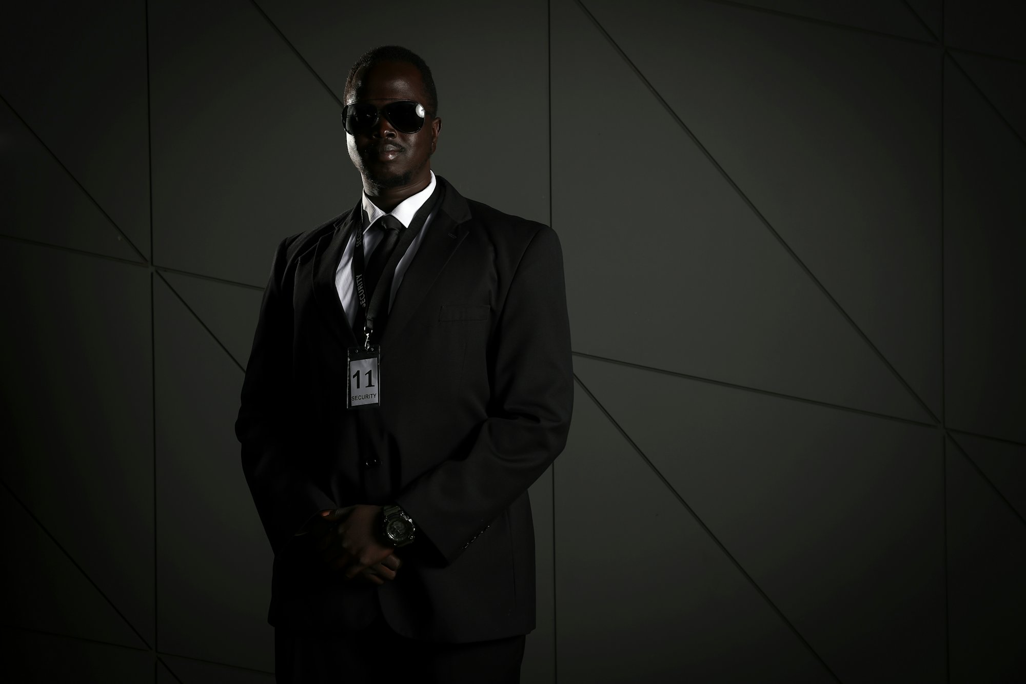 A close-protection officer in a dark suit and sunglasses